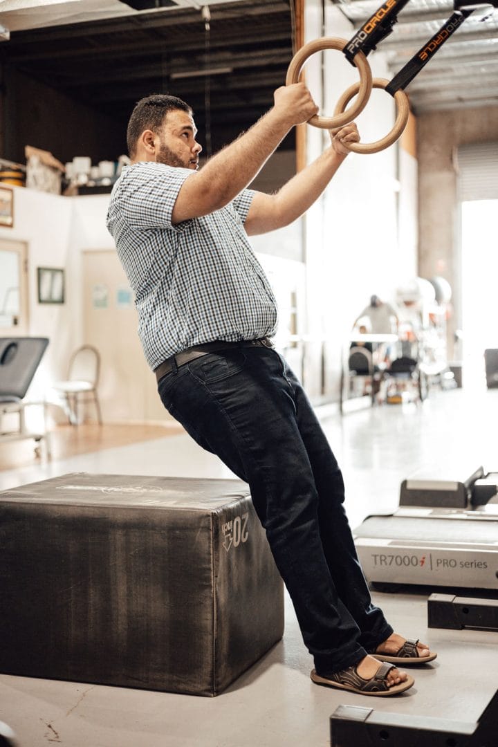 A man doing ring exercises in a disability centre.
